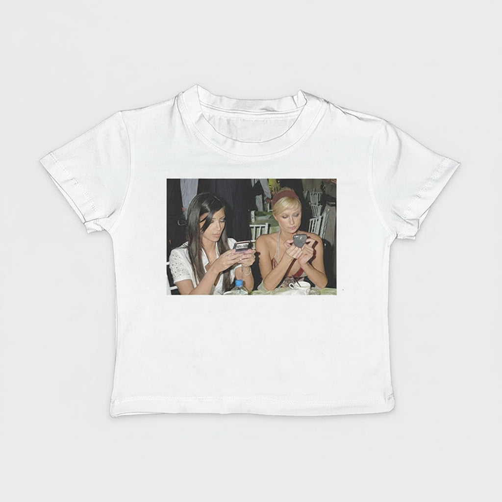 White t-shirt with a graphic of two divas on a brown background